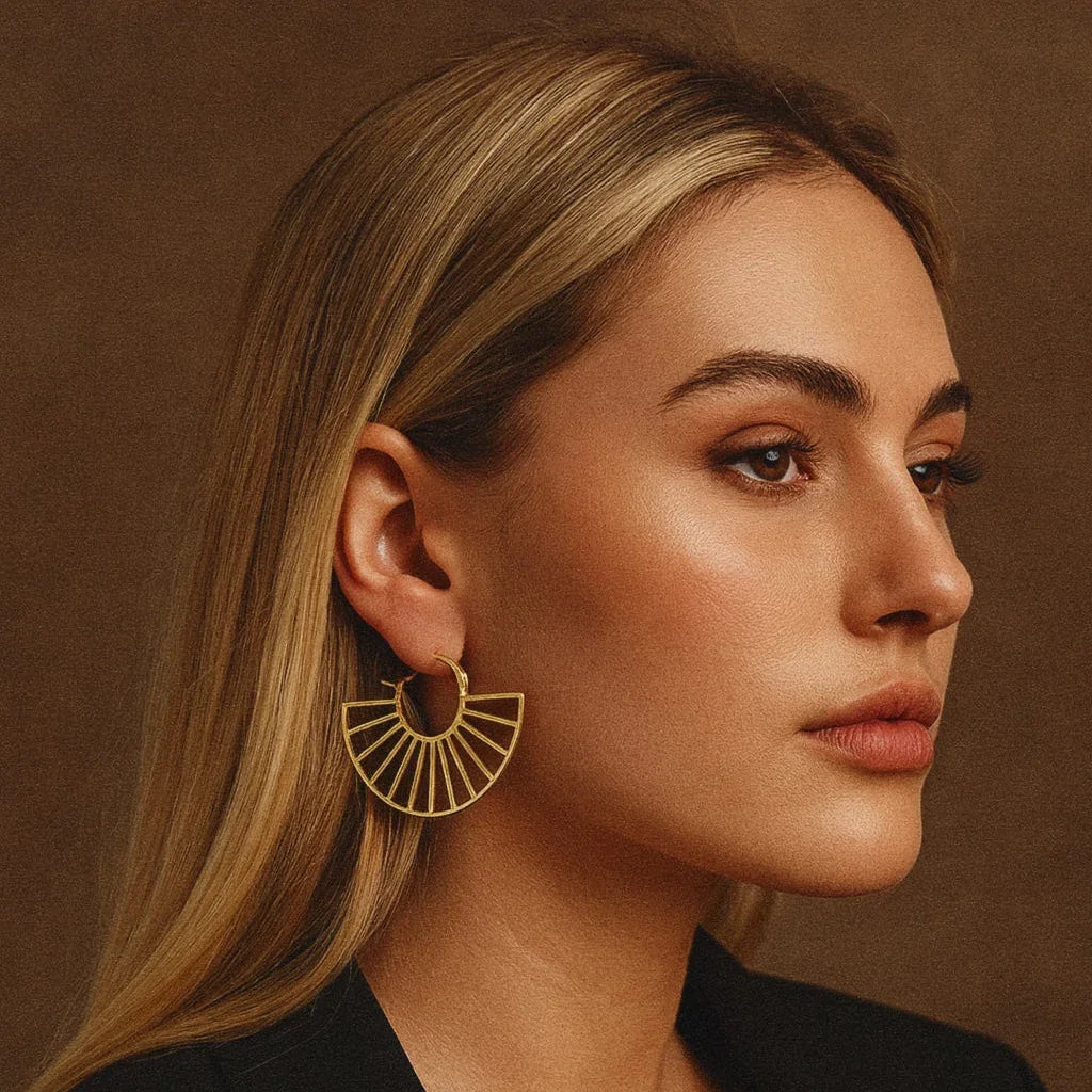 Woman wearing gold earrings against a brown background