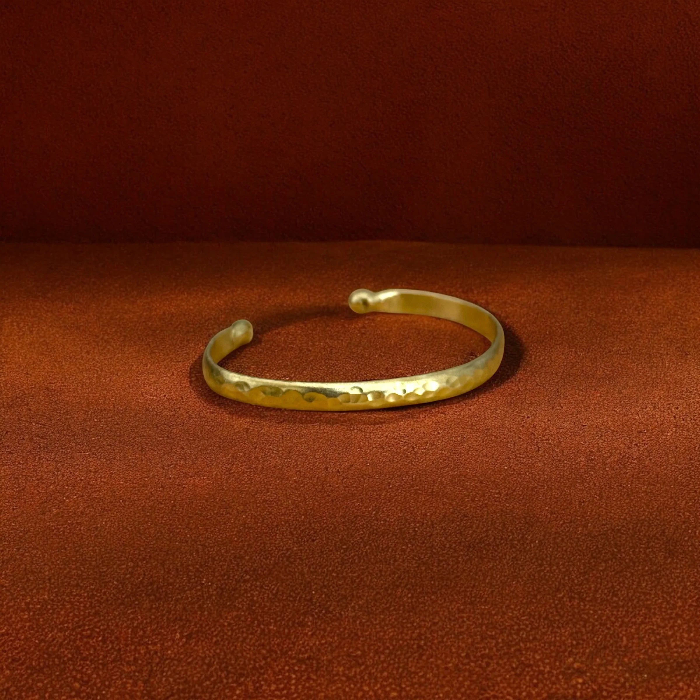 Gold bracelet on a brown fabric background