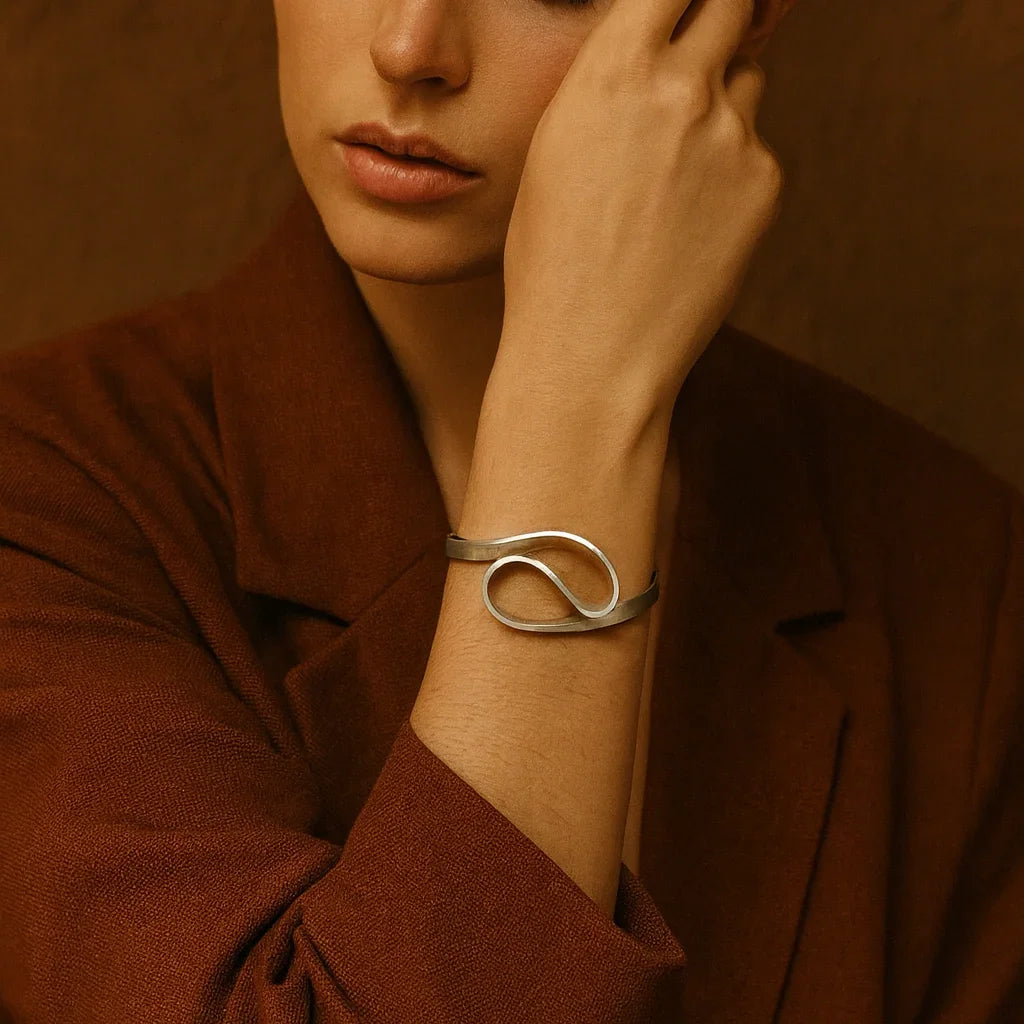 Woman wearing a silver bracelet on a brown background