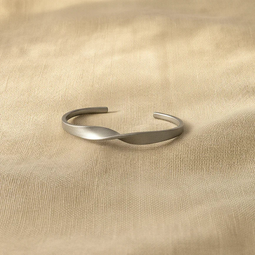 Silver bracelet on a beige fabric background