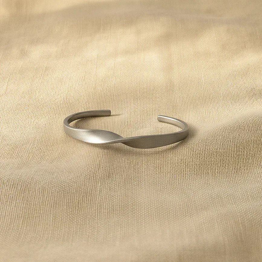 Silver bracelet on a beige fabric background