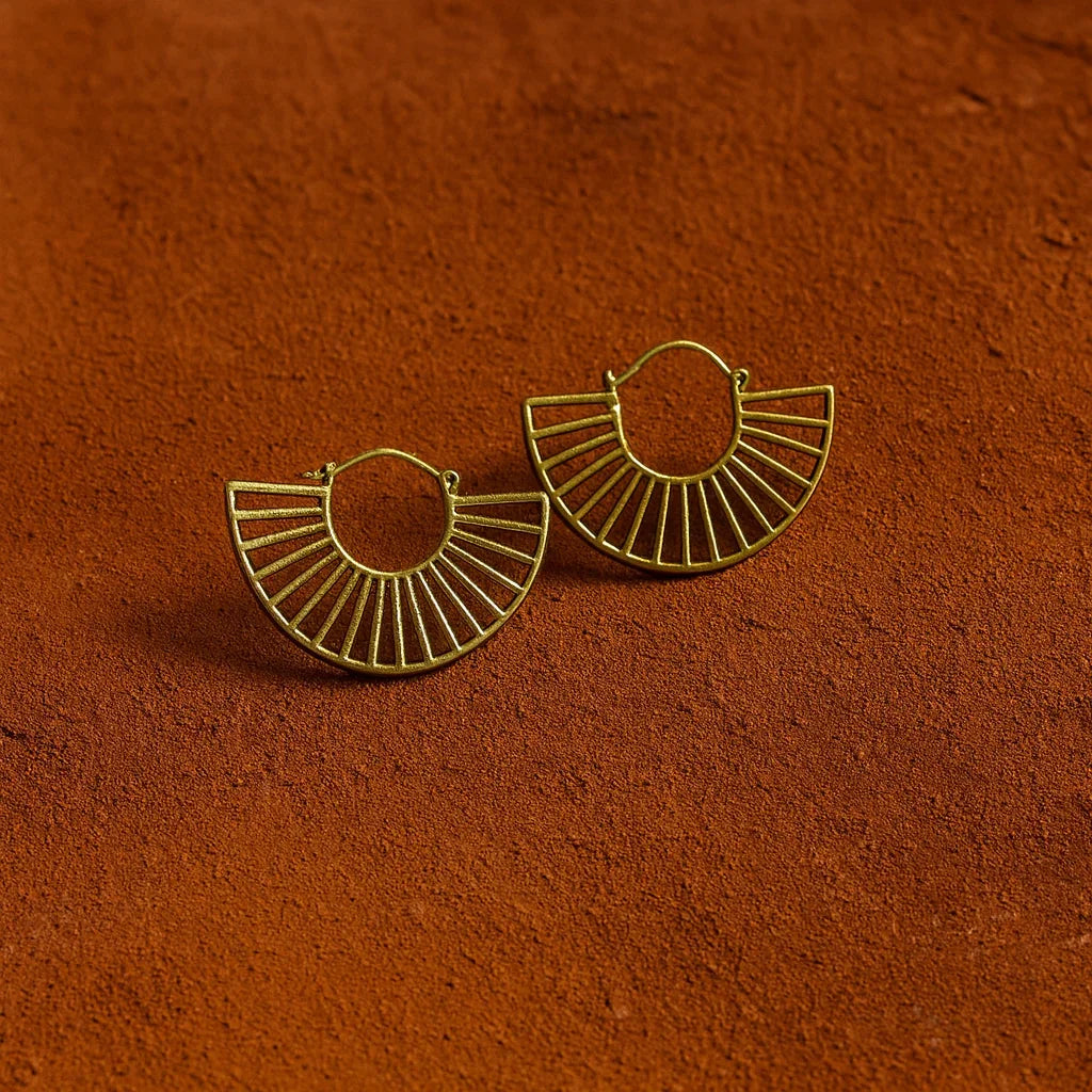 Gold hoop earrings on a textured brown surface