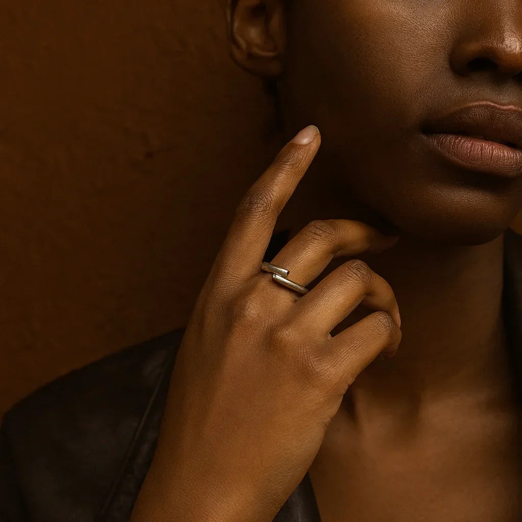Close-up of a person's hand with a ring on a brown background