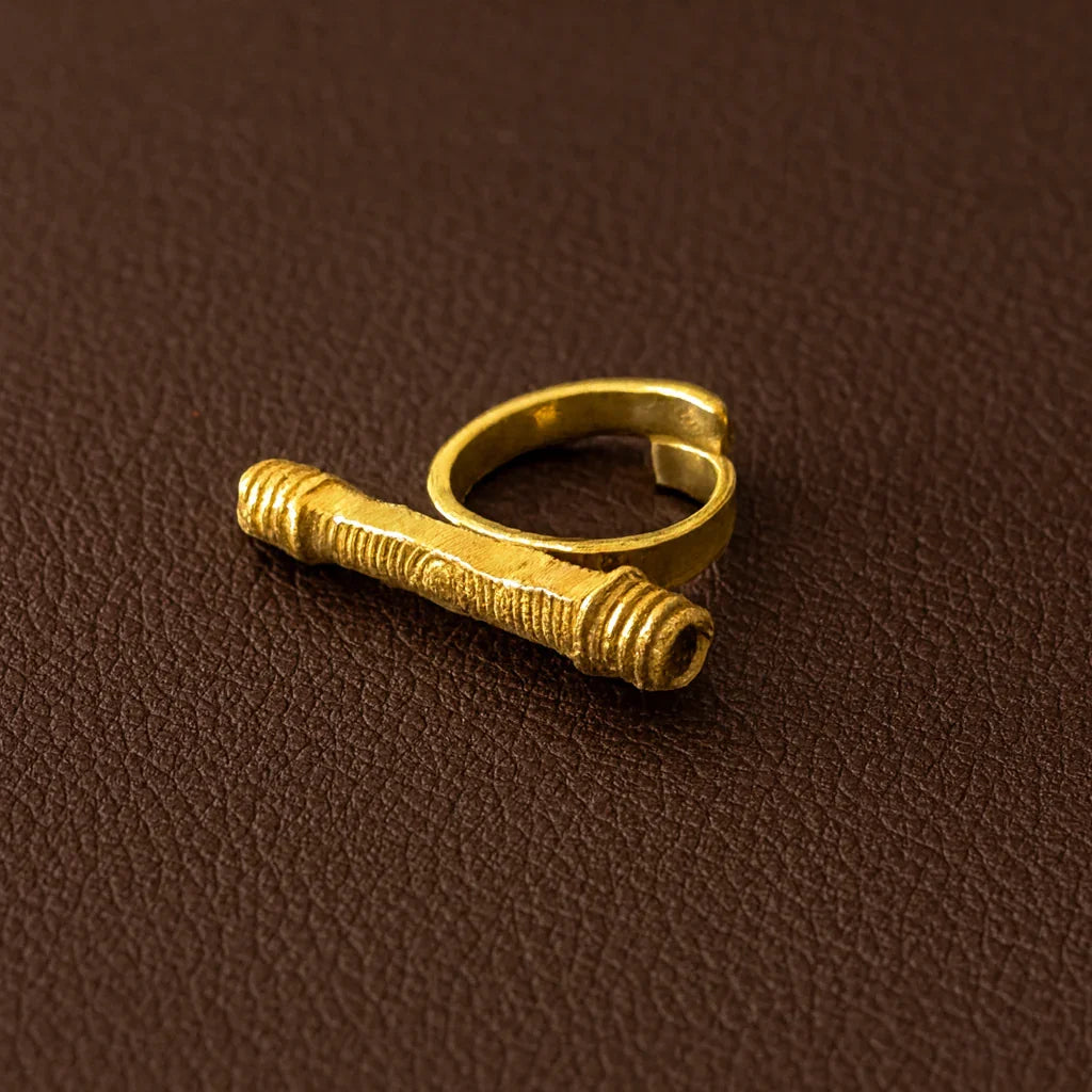 Gold ring with unique design on a brown textured background