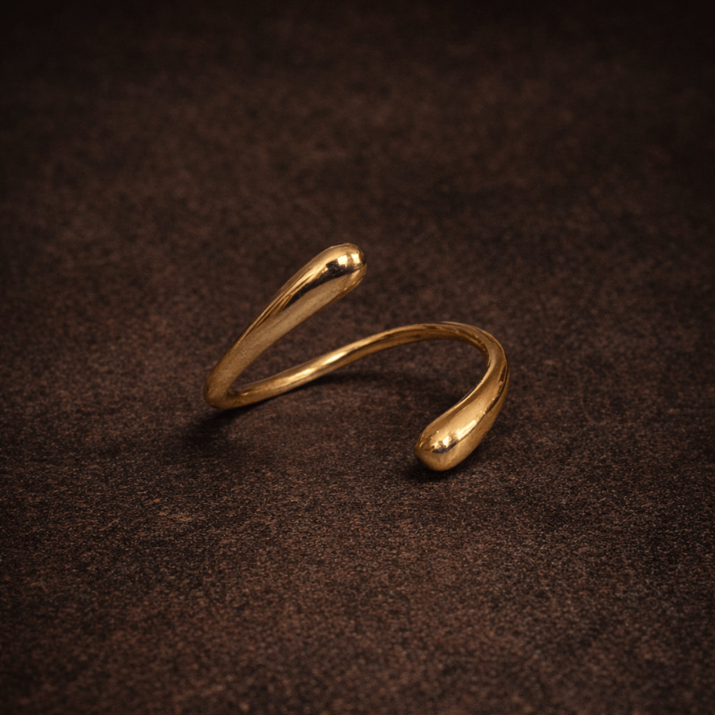 Gold open ring on a dark brown textured surface
