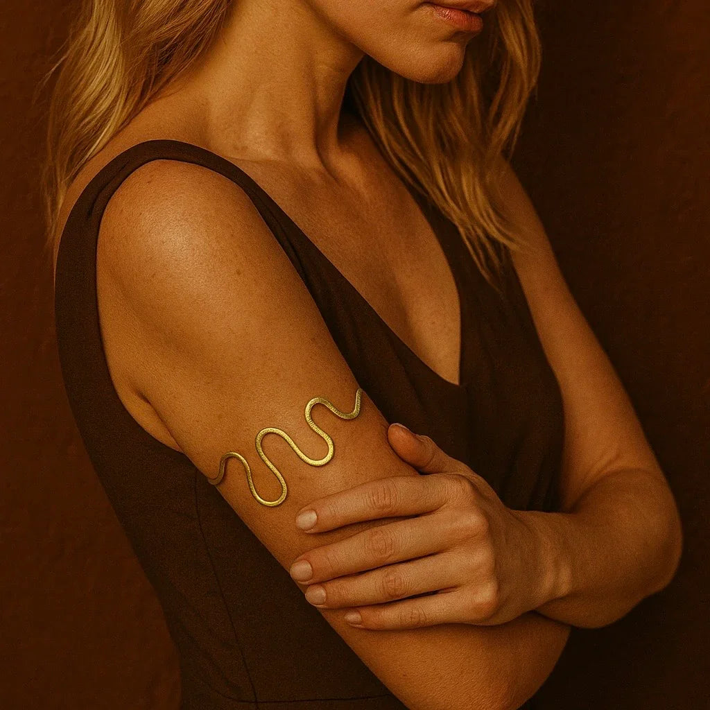 Woman with a gold tattoo on her arm against a brown background