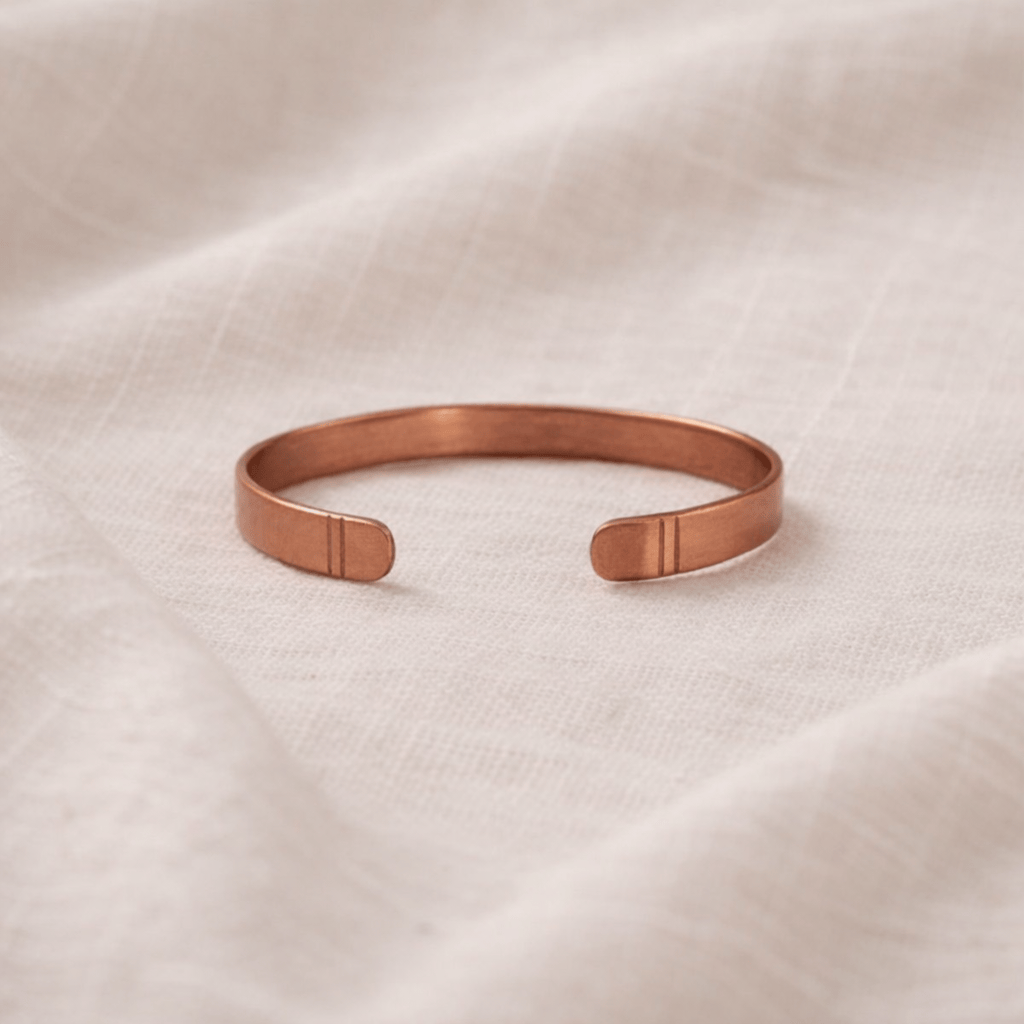Rose gold bracelet on a beige fabric background