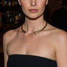 Woman wearing a gold necklace with a blurred background