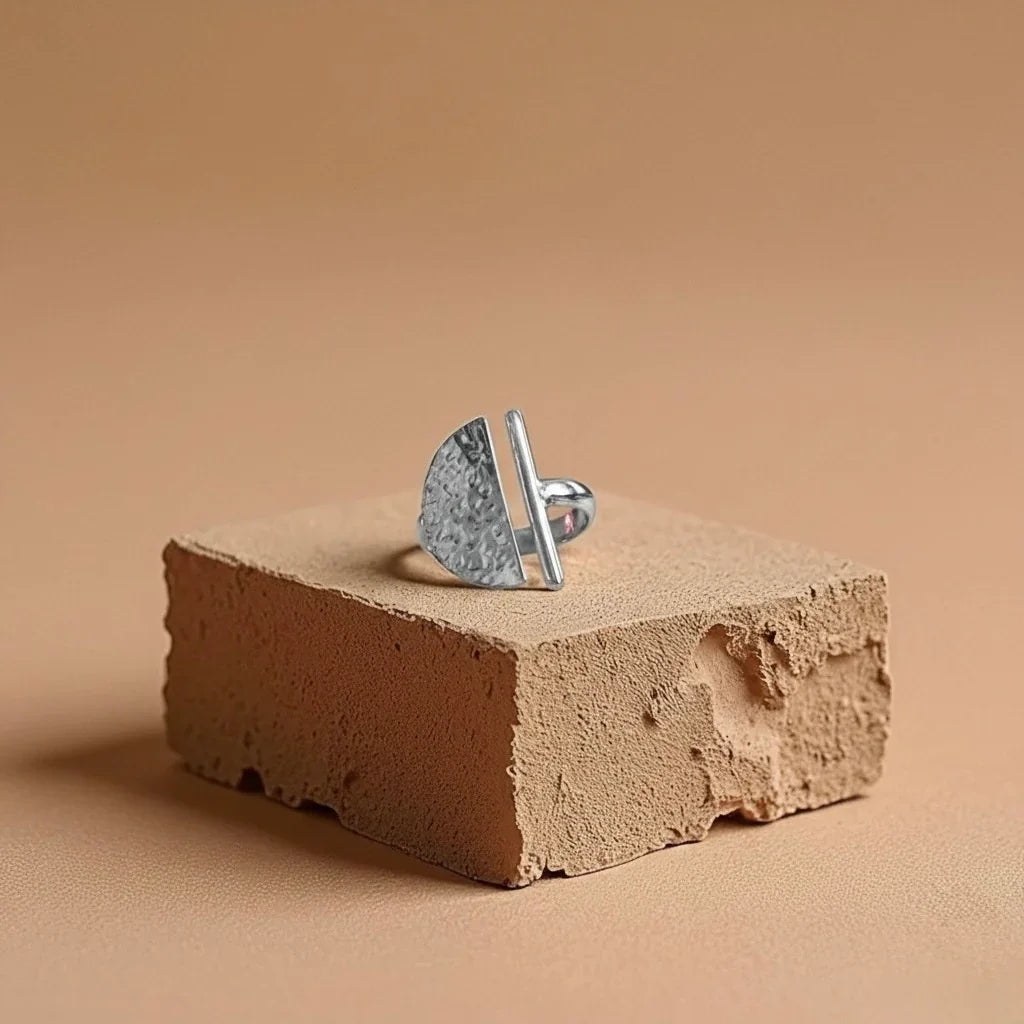 Silver ring on a textured brown surface with a beige background