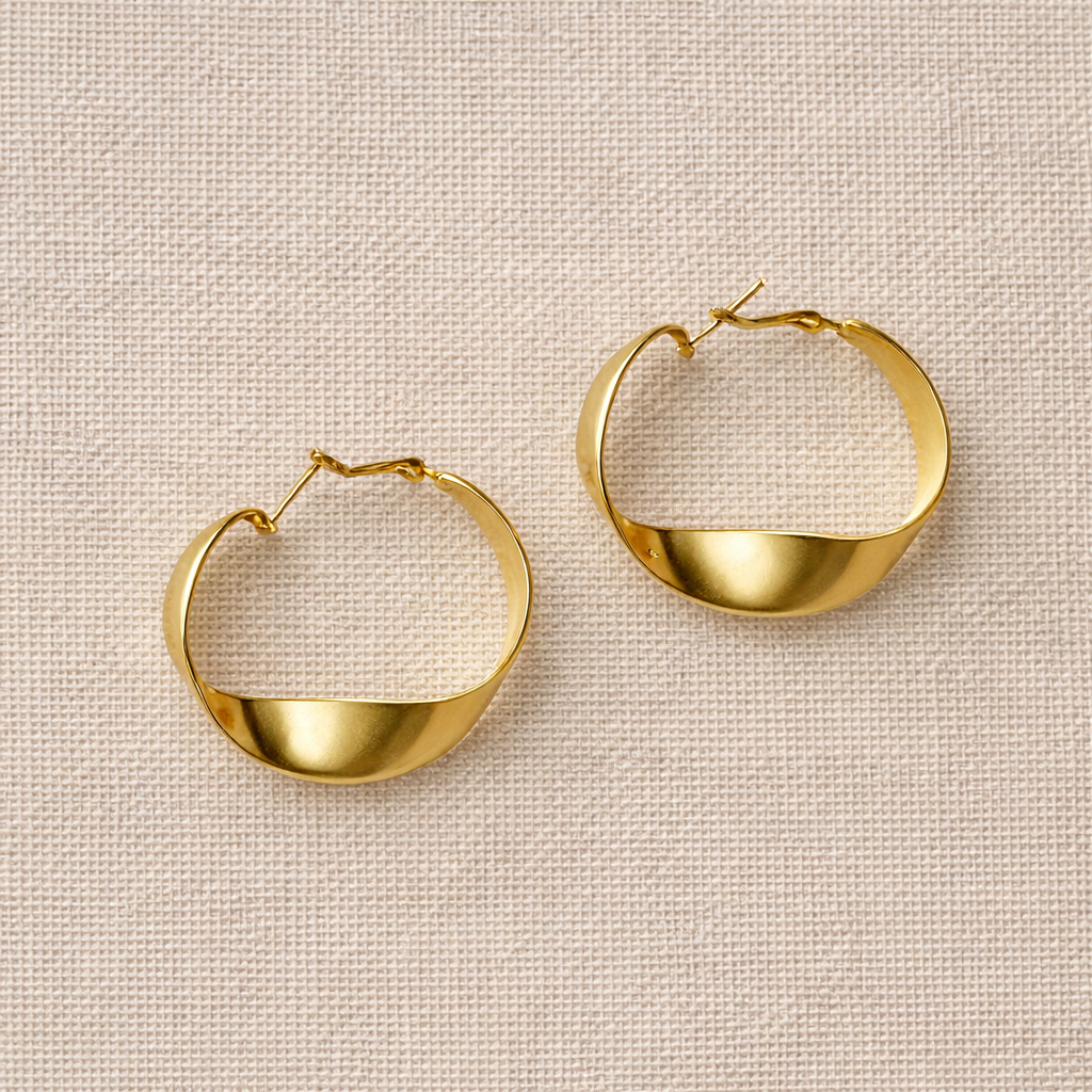 Gold hoop earrings on a beige textured background