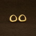 Pair of gold hoop earrings on a brown background