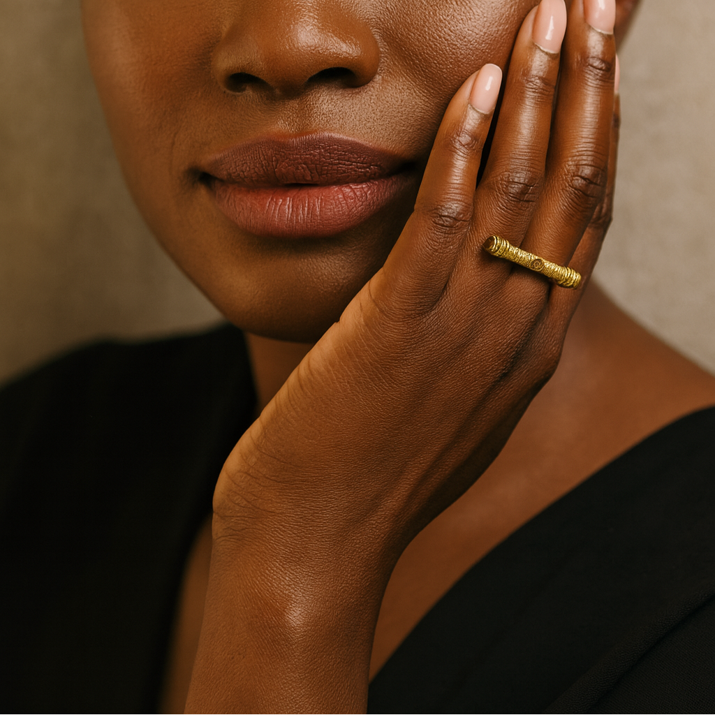 Woman with a gold ring on her finger against a neutral background