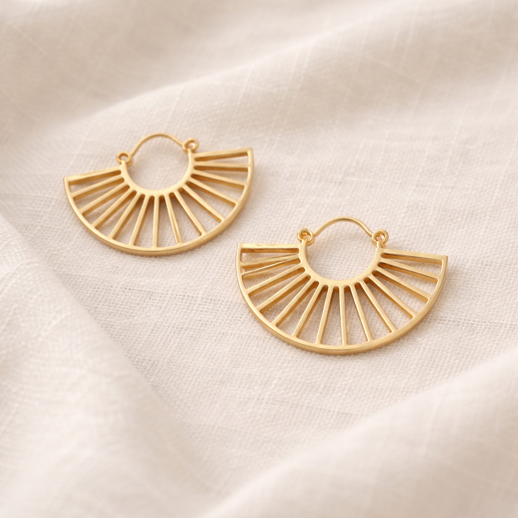 Gold hoop earrings on a beige fabric background