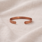 Rose gold bracelet on a beige fabric background